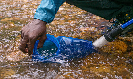 Person filling up CamelBak filtered by Lifestraw Water Bottle.