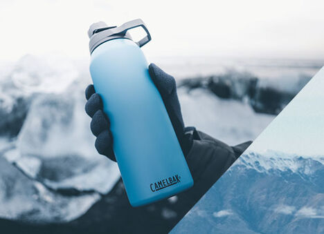 Hand holding a blue Chute Mag stainless steel water bottle. Hand holding a blue Chute Mag stainless steel water bottle.
