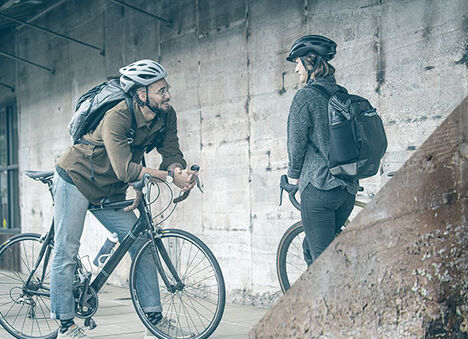 Man and women chatting while on bicycles. 