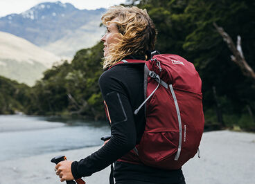 Woman hiking in the mountains wearing a Rim Runner Hydration Pack.