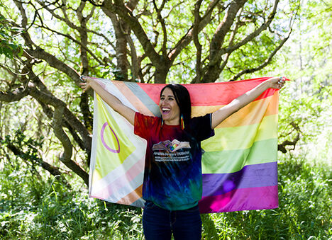Renee Ho holding up a pride flag