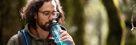 Hiker drinking from his Eddy+ Water Bottle