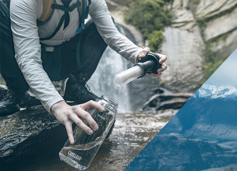 Person filling up their Eddy+ LifeStraw bottle from a stream.