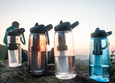 Four Eddy+ filtered by Lifestraw® bottles sitting on a rock