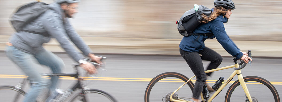 Two bikers commuting with hydration packs on