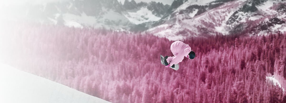 Zoe Kalapos in the air performing a snowboarding trick Zoe Kalapos in the air performing a snowboarding trick