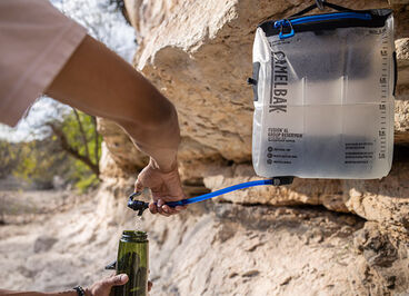 Man filling up a water bottle with water from a fusion group reservoir