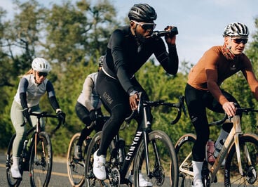 group of cyclists where one is drinking from a water bottle