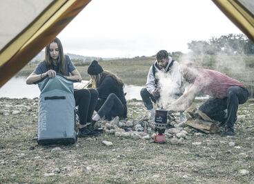 A group of friends camping with a ChillBak soft cooler.