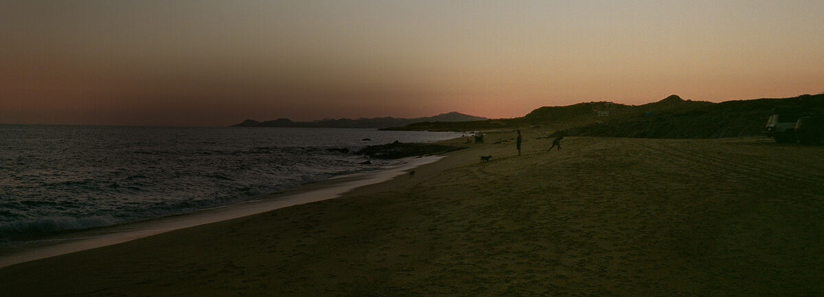 A Baja sunset on the beach with people in the distance