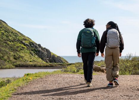 Two hikers going down a trail