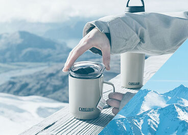Person putting the lid on a dune camp mug.