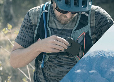 Man putting his phone in the front pocket of the Chase bike vest.