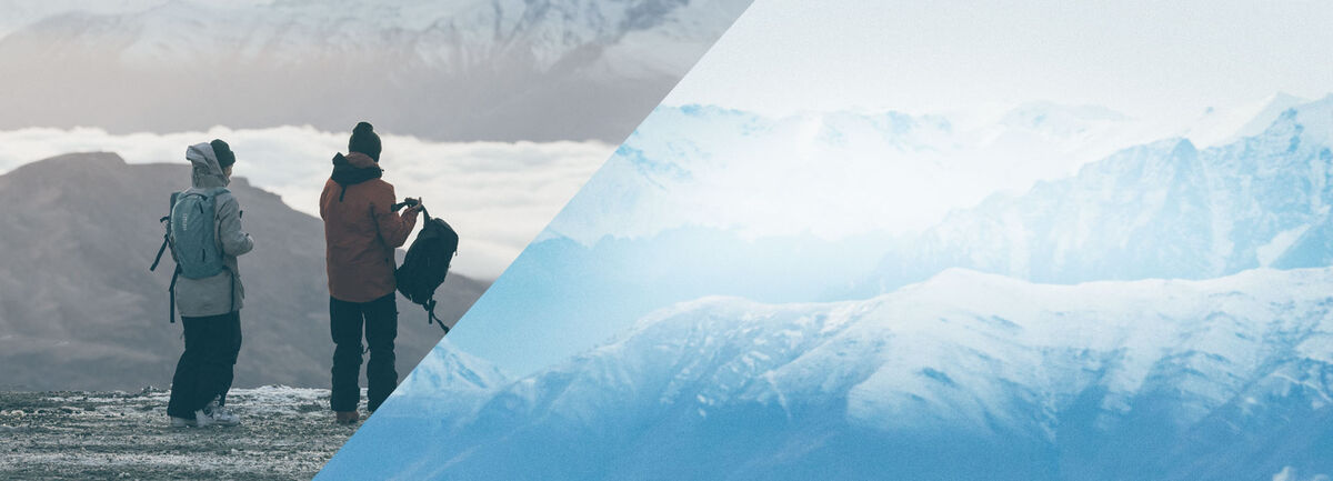 Two people looking at snowy mountains. 