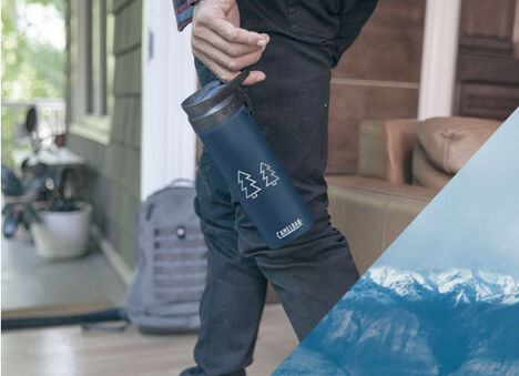 Person holding a navy forge flow bottle with mountains engraved on it.