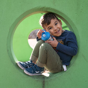 Little boy in a play structure with his CamelBak eddy+