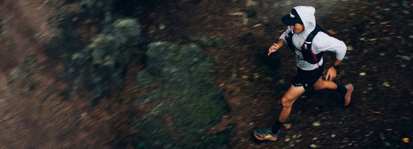 man running near rocks with a hydration pack