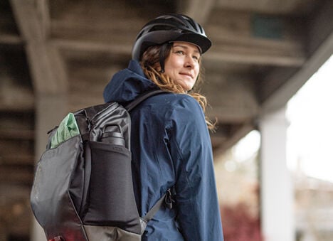 Woman wearing a MULE commute backpack. 