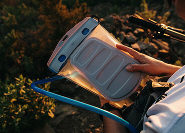 A man looking at his Fusion reservoir while on the trail