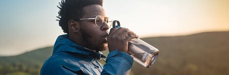 Man drinking from an Eddy+ Bottle made with Tritan Renew