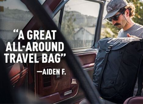 A guy getting in to his truck with his ATP travel pack and a user review to the left which reads "A Great All Around Travel Bag" from Aiden F.