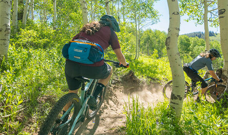 Mountain Biker on trail wearing a hydration waist pack.