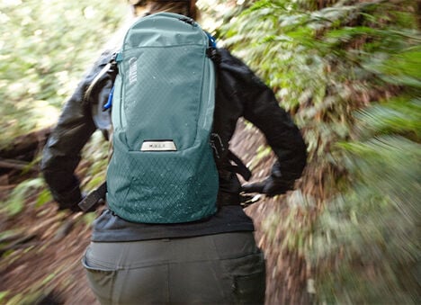 Woman mountain biker wearing a mule hydration pack.