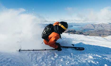 Skier carving up some snow on their way down the mountain.