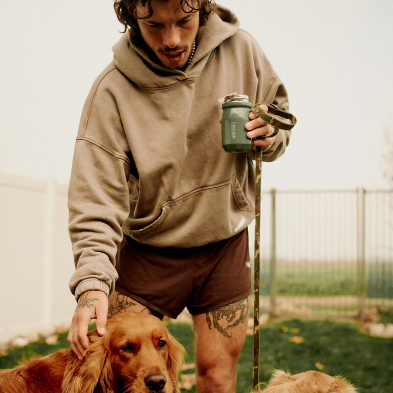 Person petting dog with tumbler