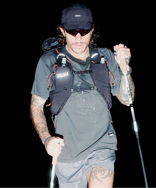 Man holding walking sticks and wearing pack