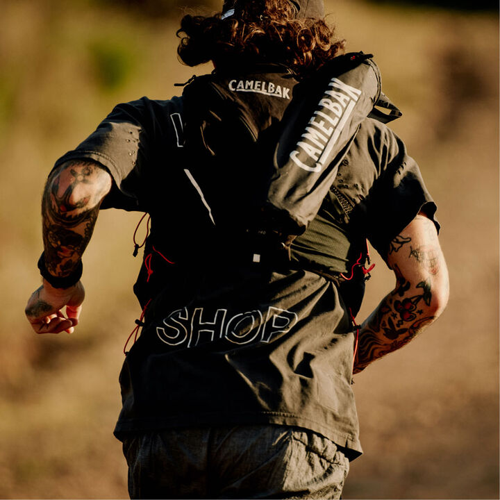 A hand holding a leash and Camelbak mug