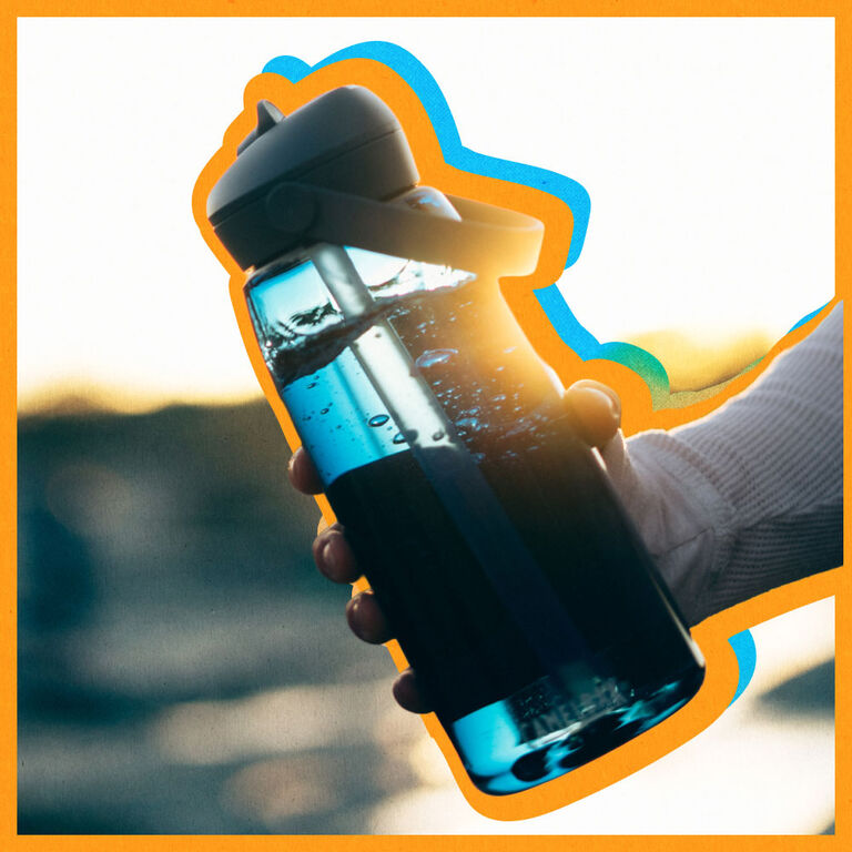 person holding a blue bottle with an orange offset treatment