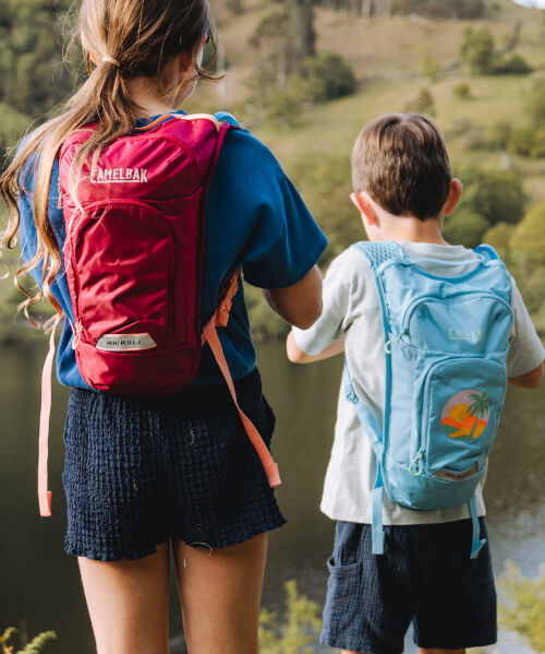 Close up of two kids wearing hiking packs
