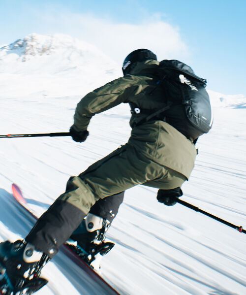 Close up of a person skiing with CamelBak snow pack on