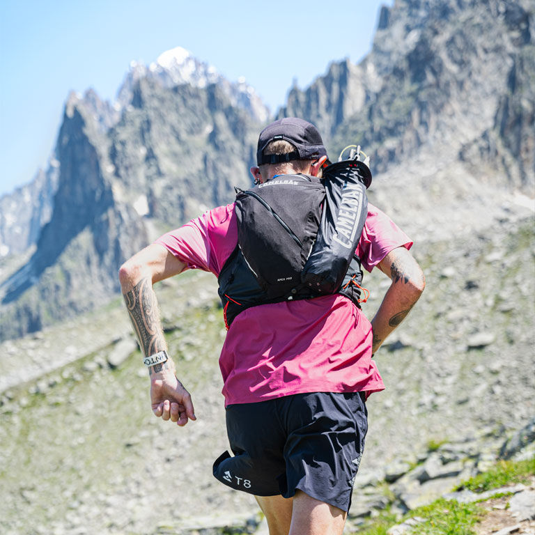 Man running with an Apex running vest Man running with an Apex running vest
