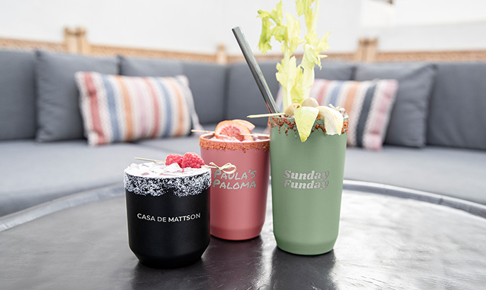 Three drinkware tumblers lined up with different laser engraved images and text. Three drinkware tumblers lined up with different laser engraved images and text.