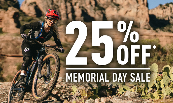 Mountain biker wearing a hydration pack with Memorial Day Sale 25% off graphic.