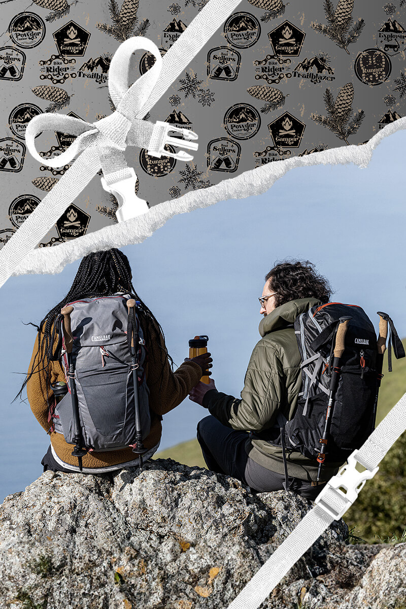 Two hikers taking a break on a mountain with holiday themed wrapping paper framing the area around him. 