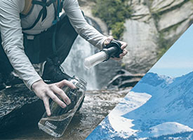 Image of a person filling up a Lifestraw bottle by a stream.
