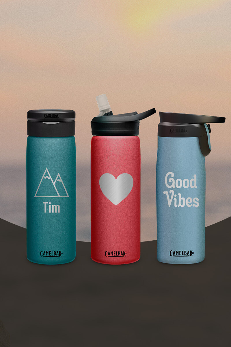 Three custom bottles engraved with different designs with a sunset background.