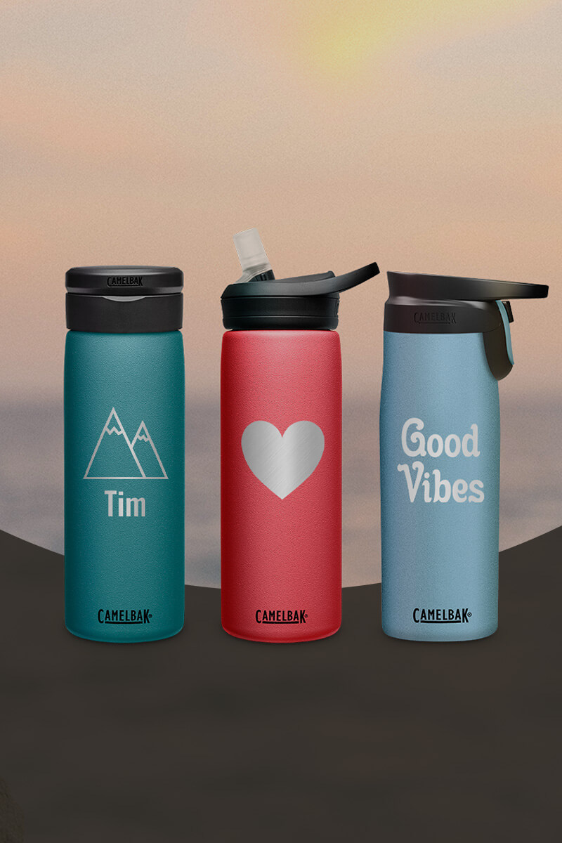 Three custom water bottles with a sunset in the background