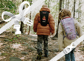 Two kids walking down a trail with their Mini M.U.L.E. hydration packs on.