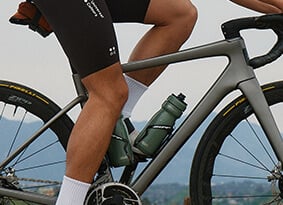 A closeup of a bicycle with two podium steel bottles on it