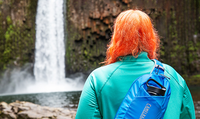 Jenny Bruso wearing her Arete sling pack on a waterfall hike.