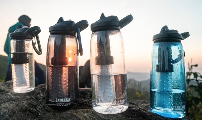 Four CamelBak filtered by Lifestraw Bottles lined up outdoors.