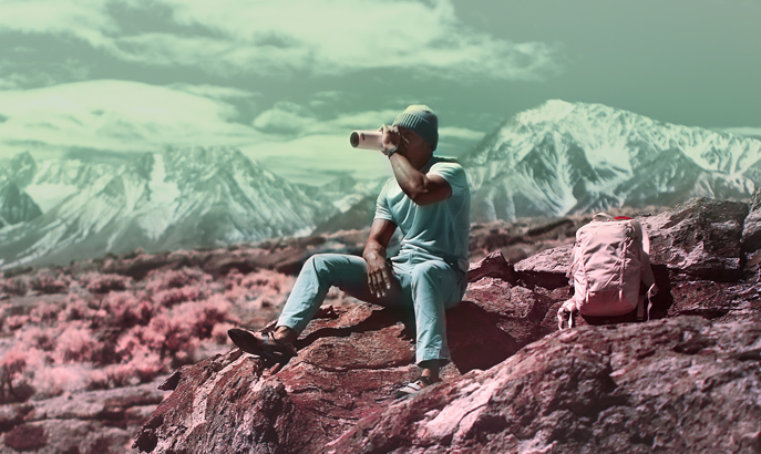 Cliford Mervil sitting on a rock drinking from a water bottle. Cliford Mervil sitting on a rock drinking from a water bottle.