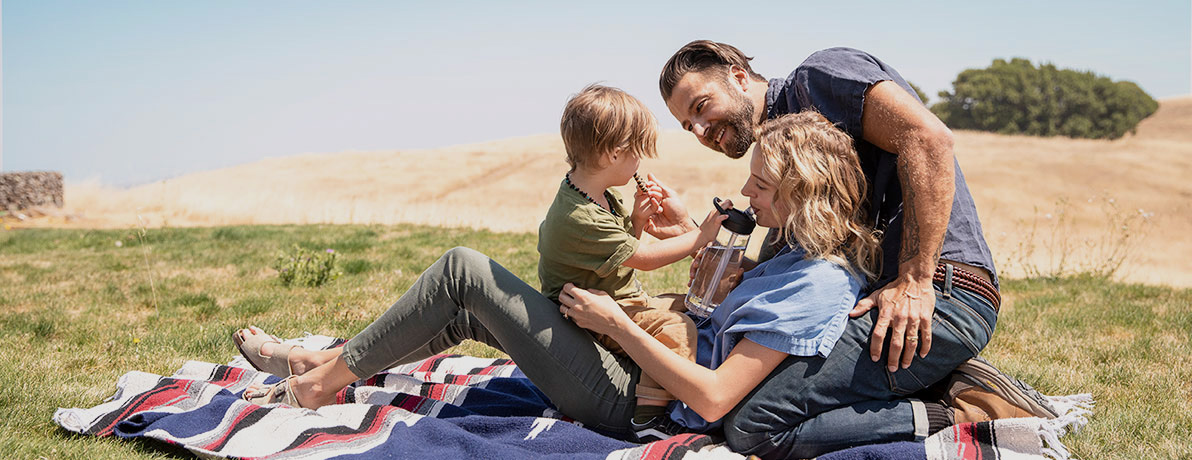 Family on Blanket sipping from water bottles. Family on Blanket sipping from water bottles.