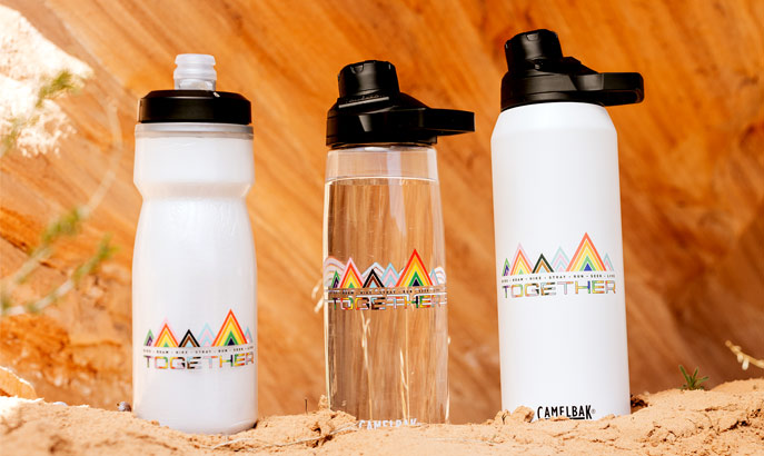 A row of three plastic water bottles lined up in front of a desert rock.. A row of three plastic water bottles lined up in front of a desert rock..